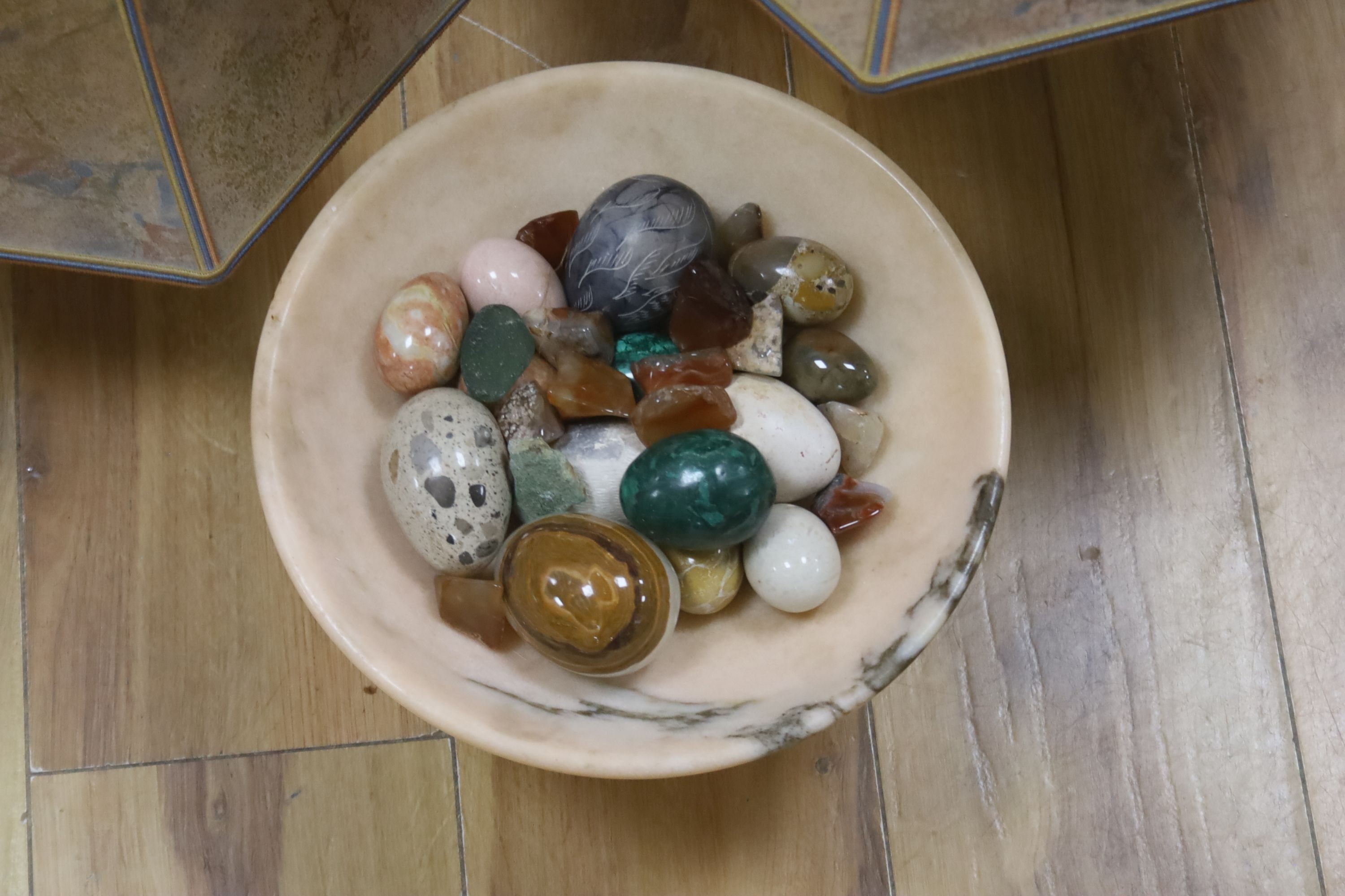 A collection polished stone eggs, dishes and three table lamps and shades.